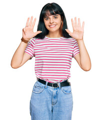 Young hispanic girl wearing casual clothes showing and pointing up with fingers number nine while...