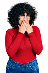Young middle east girl wearing casual clothes and glasses laughing and embarrassed giggle covering...