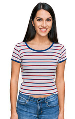 Fototapeta premium Young hispanic girl wearing casual striped t shirt with a happy and cool smile on face. lucky person.