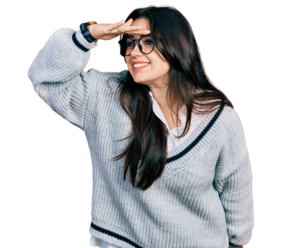 Beautiful hispanic woman wearing casual sweater and glasses very happy and smiling looking far away with hand over head. searching concept.