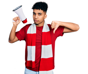 Young african american man football hooligan holding megaphone with angry face, negative sign showing dislike with thumbs down, rejection concept