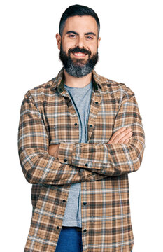 Hispanic man with beard with arms crossed gesture smiling with a happy and cool smile on face. showing teeth.