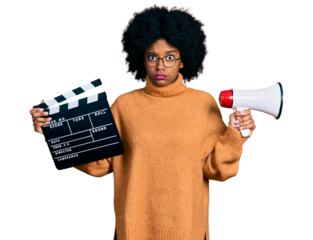 Young african american woman holding video film clapboard and megaphone skeptic and nervous, frowning upset because of problem. negative person.