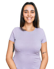 Fototapeta premium Young hispanic woman wearing casual clothes looking positive and happy standing and smiling with a confident smile showing teeth