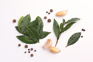 Obraz na płótnie Canvas Aromatic bay leaves and spices on white background, flat lay