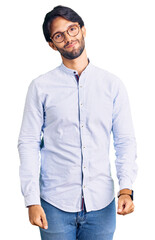 Fototapeta premium Handsome hispanic man wearing business shirt and glasses looking sleepy and tired, exhausted for fatigue and hangover, lazy eyes in the morning.