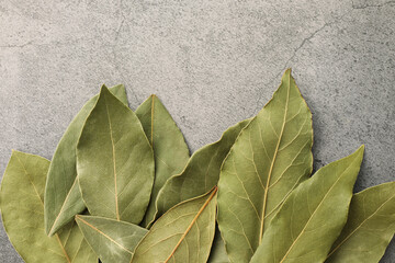 Aromatic bay leaves on light gray table, top view. Space for text