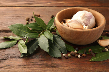 Aromatic fresh bay leaves and spices on wooden table