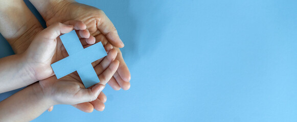 Human hand holding blue virtual hospital plus sign, healthcare, hospital, insurance, mental health...