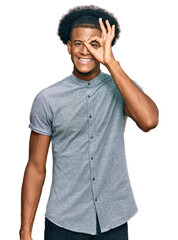 African american man with afro hair wearing casual clothes doing ok gesture with hand smiling, eye looking through fingers with happy face.