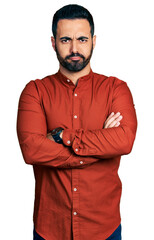 Young hispanic man with beard wearing casual shirt skeptic and nervous, disapproving expression on face with crossed arms. negative person.