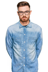 Fototapeta premium Young redhead man wearing casual denim shirt depressed and worry for distress, crying angry and afraid. sad expression.