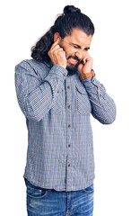 Young arab man wearing casual clothes covering ears with fingers with annoyed expression for the noise of loud music. deaf concept.