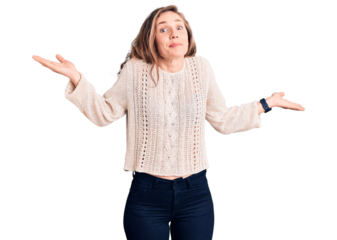 Young beautiful blonde woman wearing casual sweater clueless and confused expression with arms and hands raised. doubt concept.