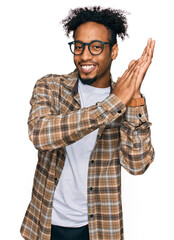 Young african american man with beard wearing casual clothes and glasses clapping and applauding happy and joyful, smiling proud hands together