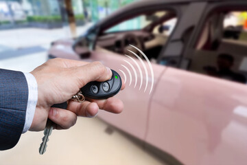 Men's hand presses on the remote control car alarm systems.