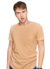 Young caucasian man wearing casual clothes in shock face, looking skeptical and sarcastic,...