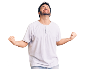 Young hispanic man wearing casual clothes very happy and excited doing winner gesture with arms raised, smiling and screaming for success. celebration concept.