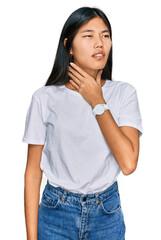 Fototapeta premium Beautiful young asian woman wearing casual white t shirt touching painful neck, sore throat for flu, clod and infection