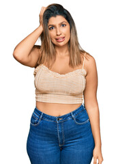 Fototapeta premium Beautiful brunette woman wearing casual clothes confuse and wonder about question. uncertain with doubt, thinking with hand on head. pensive concept.
