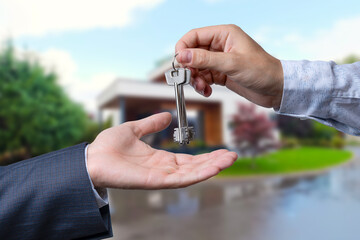 Handing Over The New House Keys with Home in the Background.