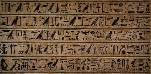 Fototapeta na wymiar Old Egyptian hieroglyphs on an ancient background. Wide historical background. Ancient Egyptian hieroglyphs as a symbol of the history of the Earth.
