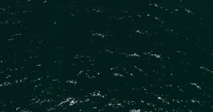 A drone flies over the dark waves of the sea