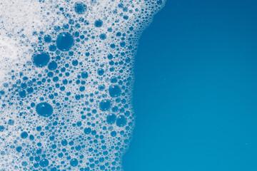 Detergent foam bubble on water. Blue background, Soap sud
