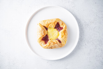 Vanilla cream raspberry jam sweet bun in a plate
