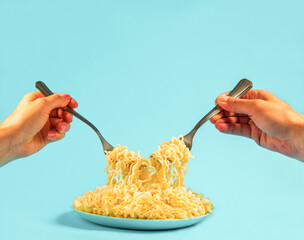 Man and woman eating spaghetti together. CLose up female and male hands with forks and pasta on blue background. Copy space.