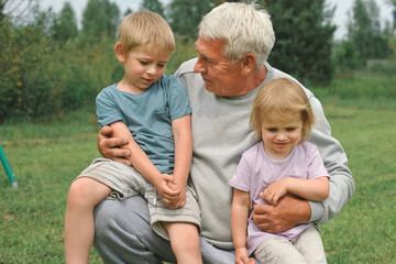 Grandfather and grandchildren have fun during walk In Park. Happy family time. Old man grandpa...