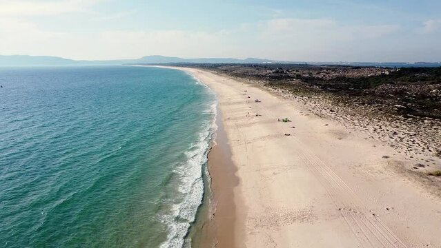 Praia da Comporta Portugal, Big beach with turquise water, big horizon, afternoon big dune, blue sky