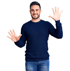 Naklejka premium Young handsome man wearing casual clothes showing and pointing up with fingers number ten while smiling confident and happy.