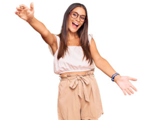 Young hispanic woman wearing casual clothes and glasses looking at the camera smiling with open arms for hug. cheerful expression embracing happiness.