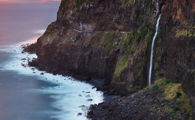 Madeira island - Dramatic sunrise over atlantic ocean with waterfall landscape from Miradouro do Veu da Noiva