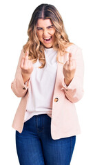 Young caucasian woman wearing business clothes showing middle finger doing fuck you bad expression,...