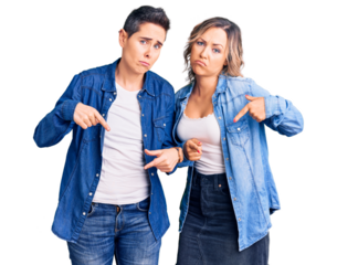 Couple of women wearing casual clothes pointing down looking sad and upset, indicating direction with fingers, unhappy and depressed.
