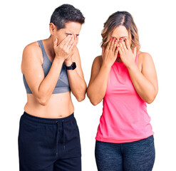 Couple of women wearing sportswear rubbing eyes for fatigue and headache, sleepy and tired expression. vision problem