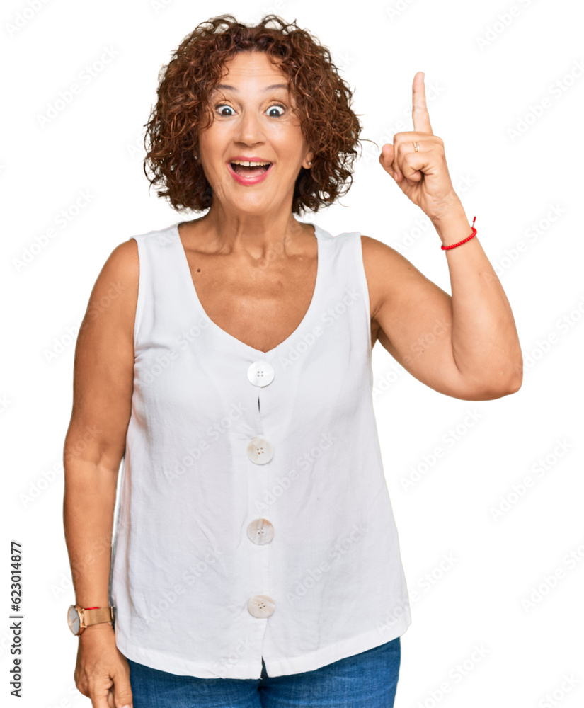 Sticker Beautiful middle age mature woman wearing casual white shirt pointing finger up with successful idea. exited and happy. number one.