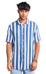 Young hispanic man wearing casual clothes relaxed with serious expression on face. simple and natural looking at the camera.