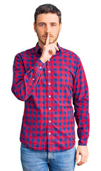 Fototapeta premium Handsome young man with bear wearing casual shirt asking to be quiet with finger on lips. silence and secret concept.