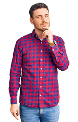 Fototapeta na wymiar Handsome young man with bear wearing casual shirt with hand on chin thinking about question, pensive expression. smiling with thoughtful face. doubt concept.