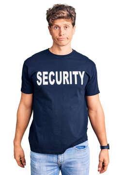 Young handsome man wearing security t shirt depressed and worry for distress, crying angry and afraid. sad expression.