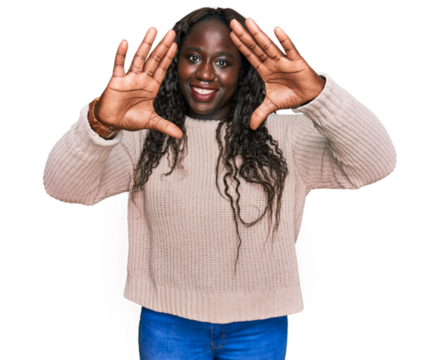 Young african woman wearing wool winter sweater doing frame using hands palms and fingers, camera perspective