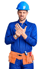 Young handsome man wearing worker uniform and hardhat touching painful neck, sore throat for flu, clod and infection