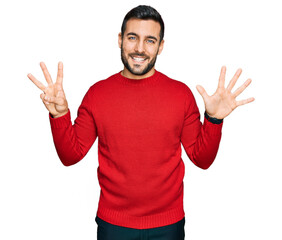 Young hispanic man wearing casual clothes showing and pointing up with fingers number eight while smiling confident and happy.