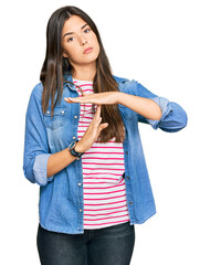 Young brunette woman wearing casual clothes doing time out gesture with hands, frustrated and serious face