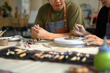 Fototapeta premium Man modeling clay in pottery workshop, creative activity, handicraft and hobbies concept