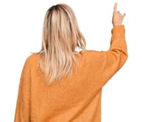 Middle age caucasian woman wearing casual winter sweater posing backwards pointing ahead with finger hand