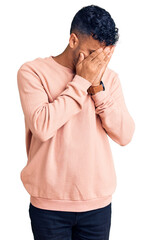 Young hispanic man wearing casual clothes with sad expression covering face with hands while crying. depression concept.